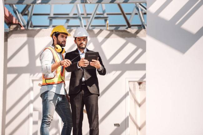 civil engineer construction worker manager holding digital tablet blueprints talking planing about construction site cooperation teamwork concept 1 650x434 1