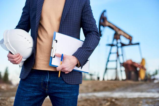 cropped snapshot inspector oil field holding folder notes helmet 650x434 1